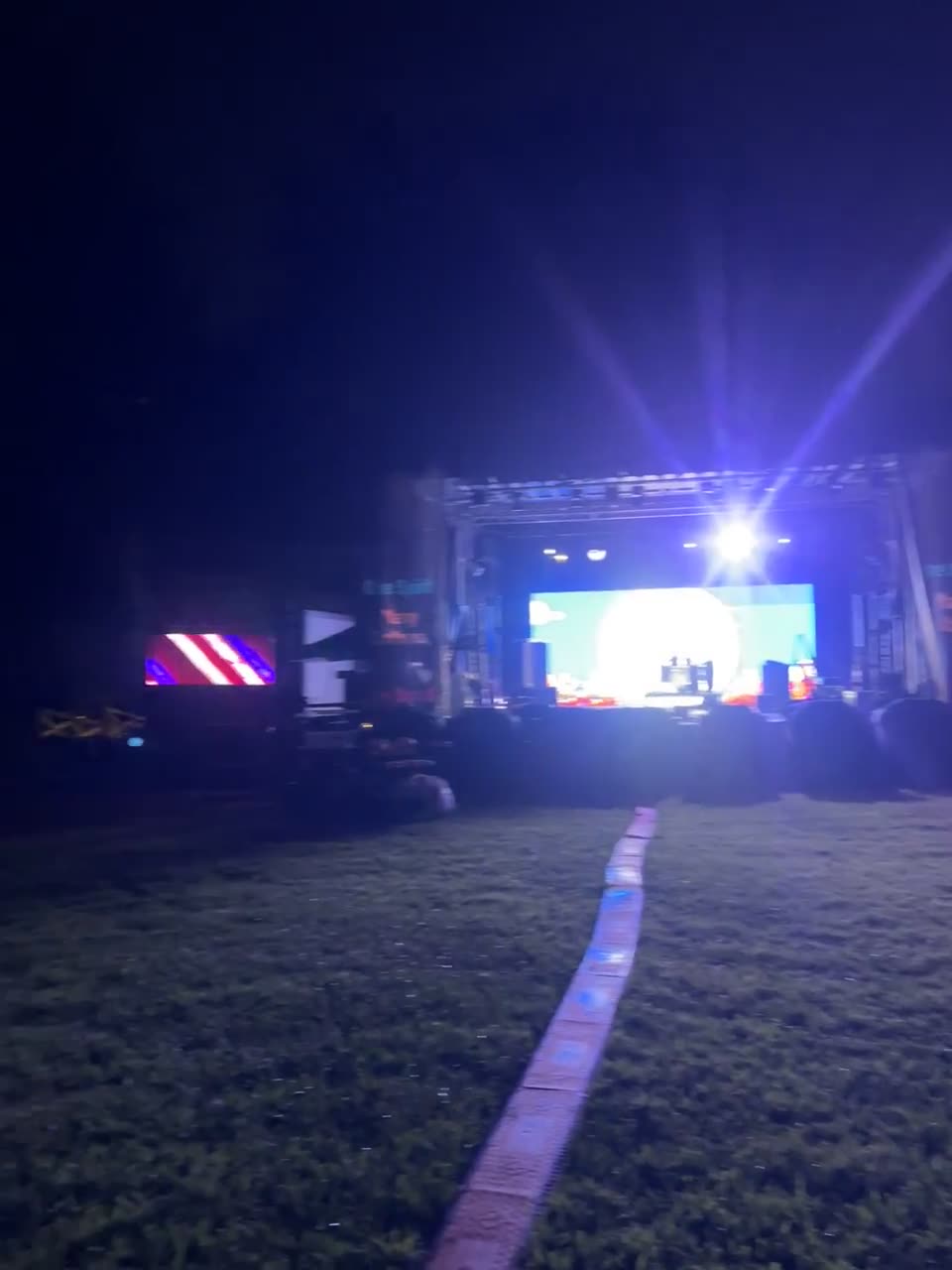 Wide view of an arena stage with LED video wall and lighting rig
