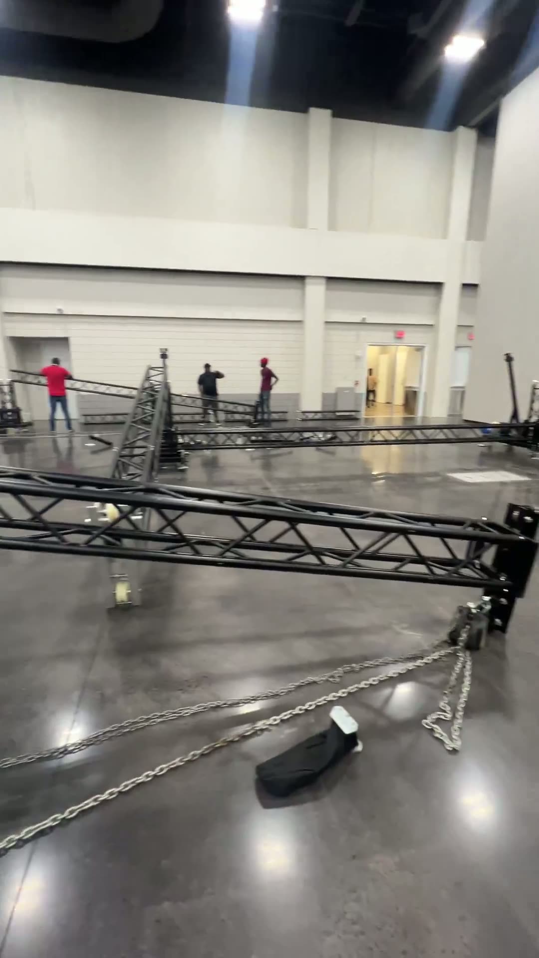 Crew assembling ground-support truss on a convention center floor