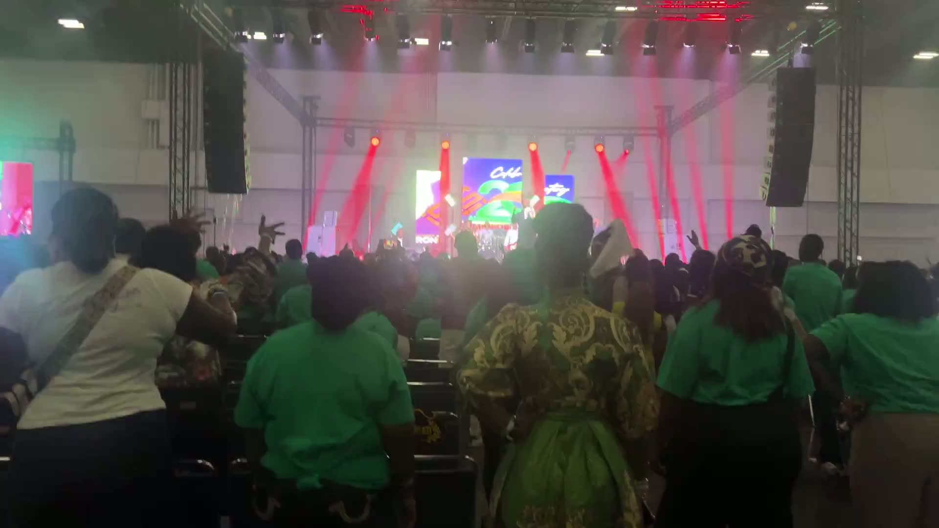 Crowd standing in front of a brightly lit main stage