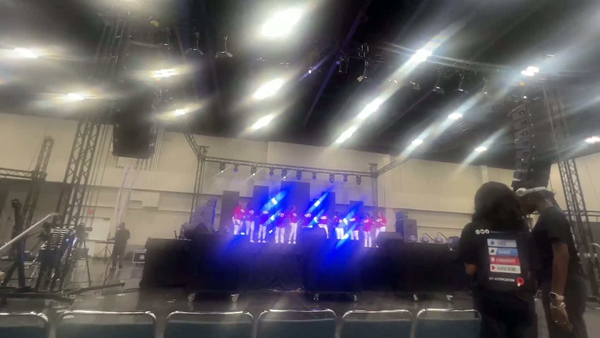 Band performing under moving-head stage lighting
