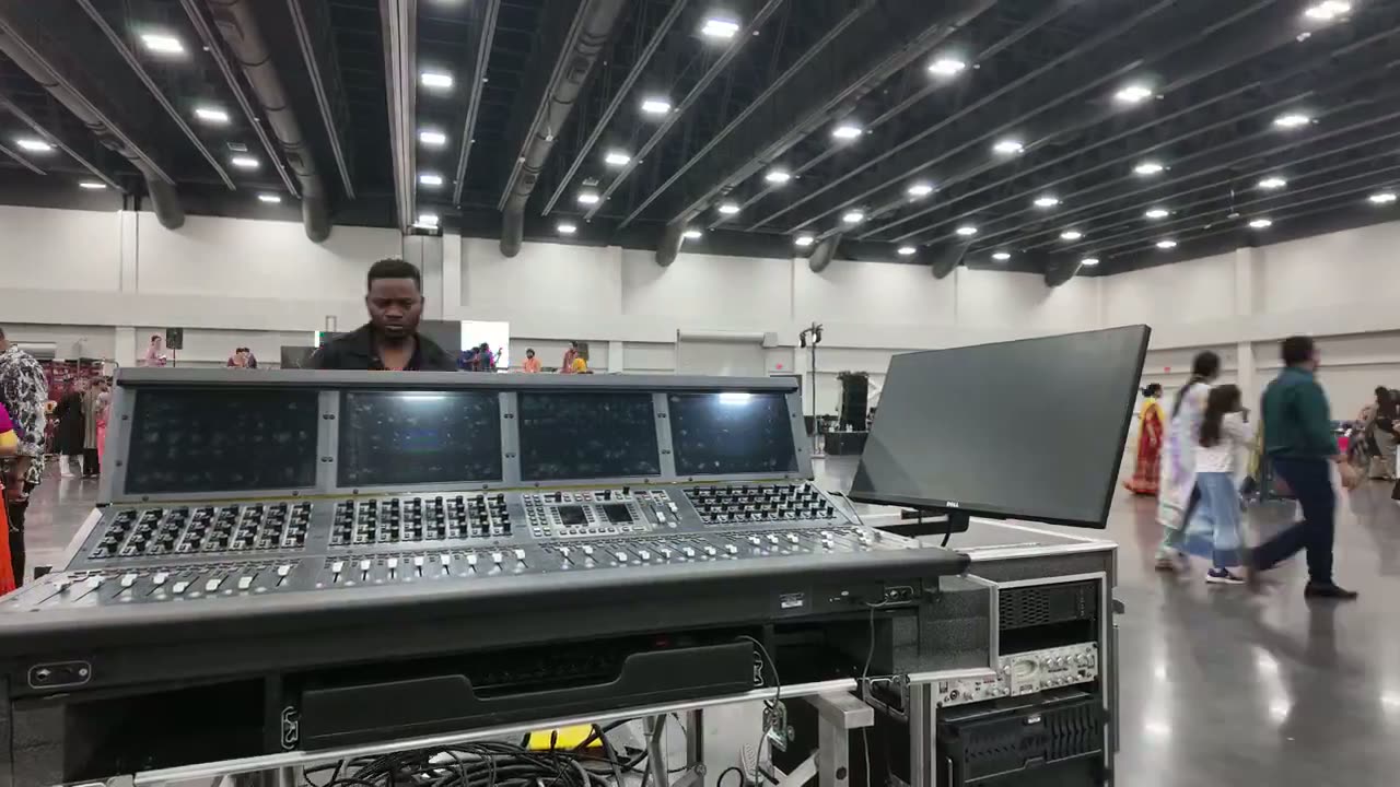 Mixing console and rack gear at front of house inside a convention center hall