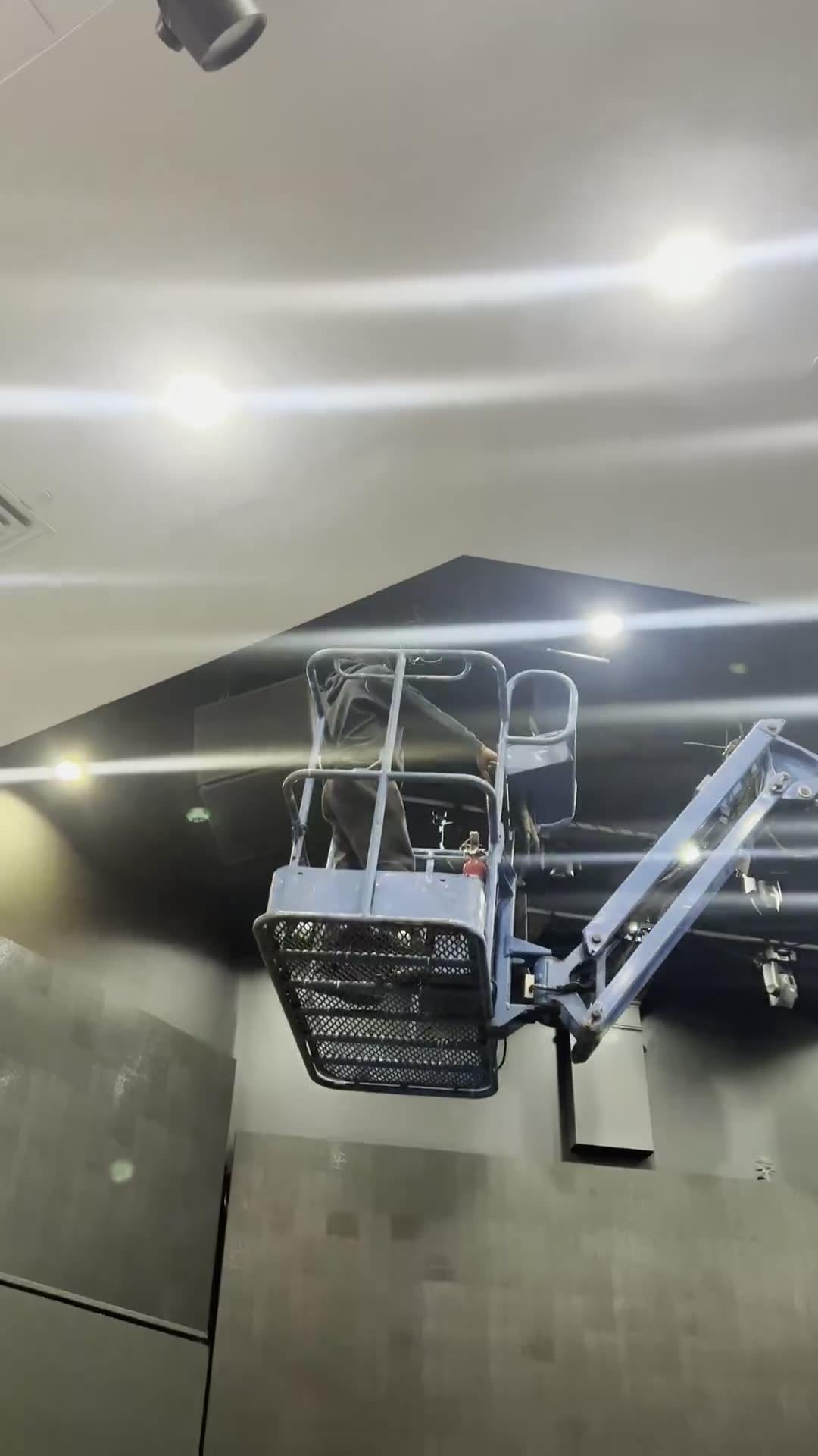 Scissor lift raised to ceiling height during an overhead rigging install
