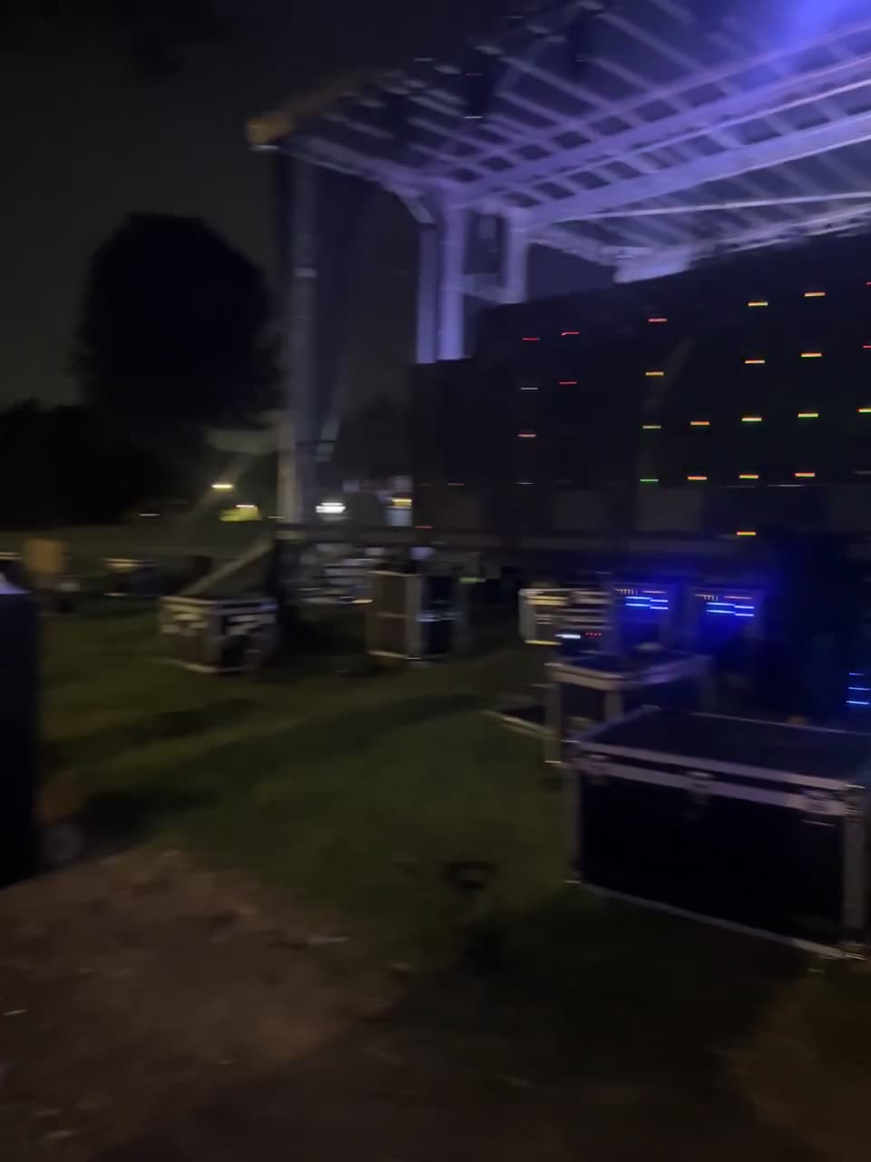 Lighting beams cutting through haze above an arena stage