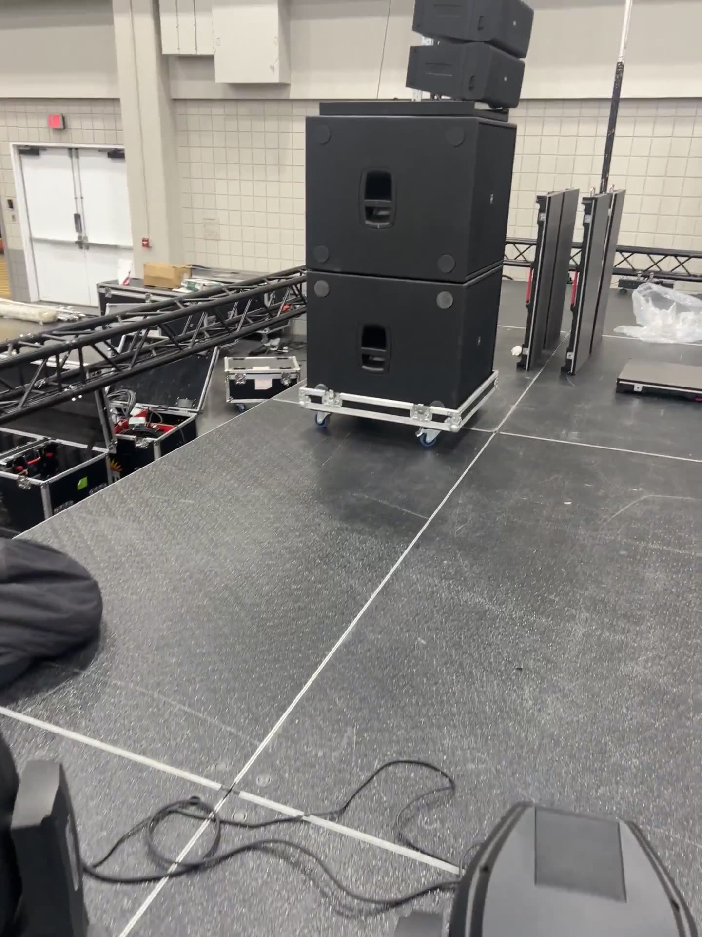 Subwoofer stack on carts beside truss and staging decks