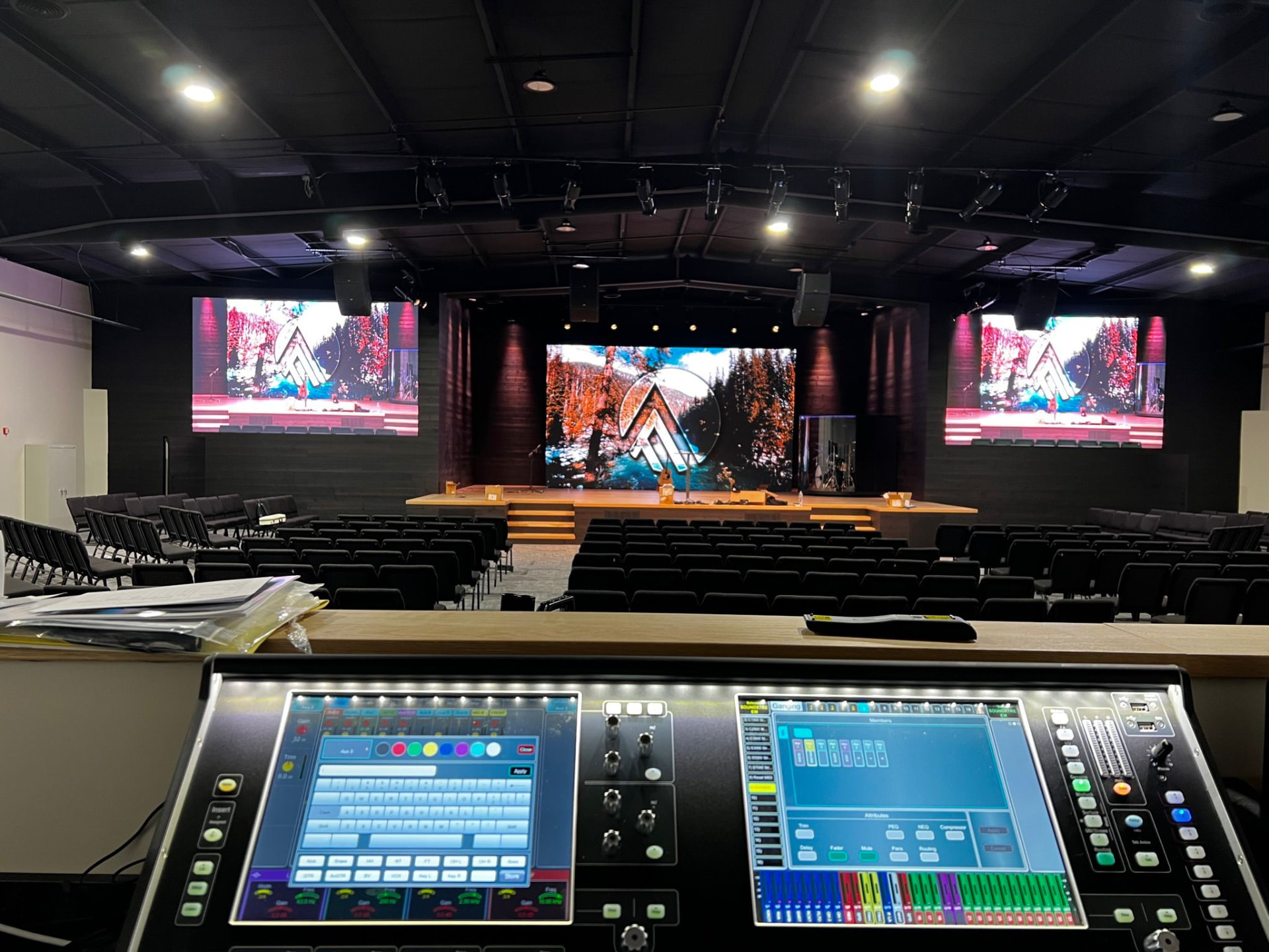Church sanctuary with dual LED side screens, center LED wall, line-array PA and a digital console at FOH